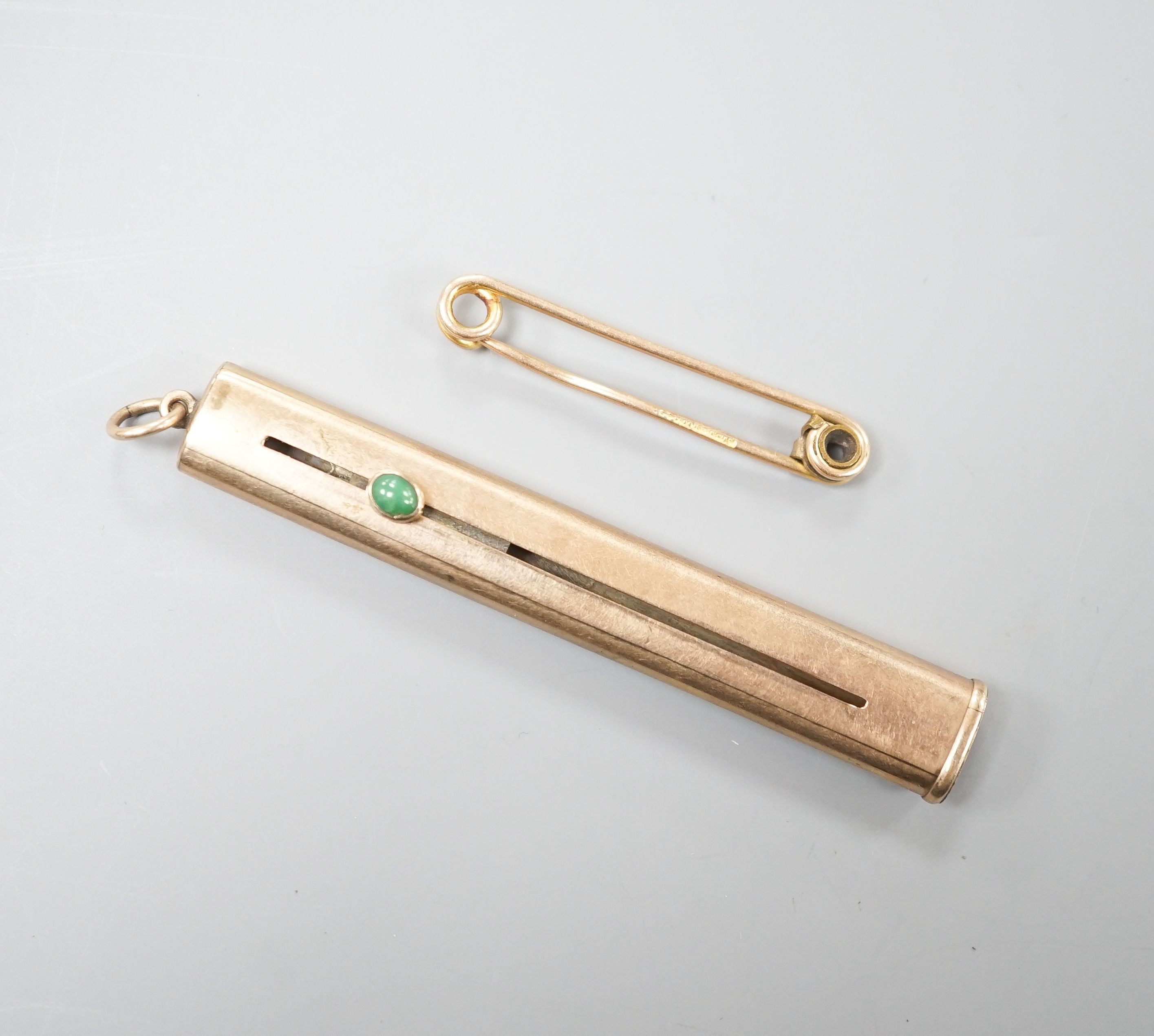 A 9ct. gold cased propelling pencil (no pencil), 7cm and a yellow metal pin, gross 7.4 grams.